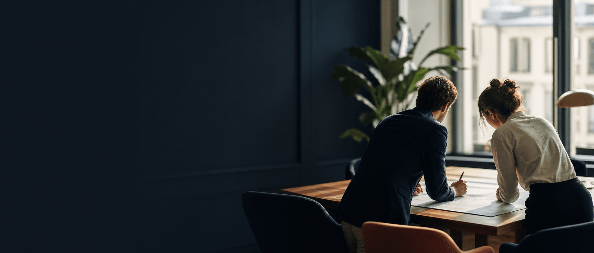 Deux professionnels préparent un plan dans un espace de travail lumineux